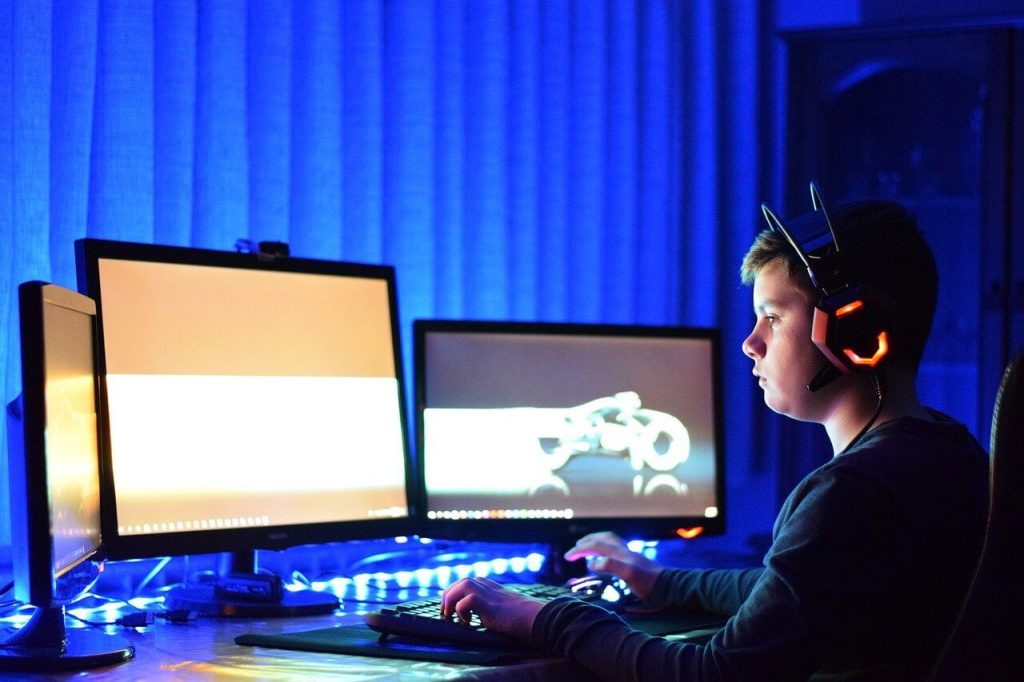 Niño usando cascos bluetooth gaming para jugar videojuegos